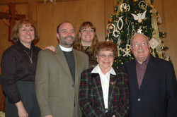 Mom & Dad in the foreground, with their 3 grown children behind, and a Christmas tree in the background